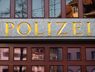 Fototapeta na wymiar Zug, Switzerland - December 31, 2021: The window of the police station in Zug, Switzerland, with the german inscription Polizei - in translation Police