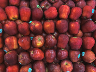 Many ripe juicy red apples as background