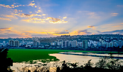 Naklejka premium Beautiful Sunrise over tall buildings and Jambhulwadi lake in Pune, Maharashtra, India