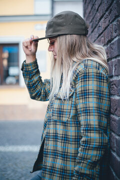 Woman In Hat And Flannel Shirt On The Street