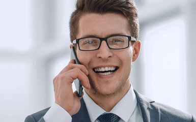 smiling young businessman talking on smartphone
