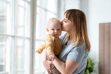 Mom gently kisses her baby son.