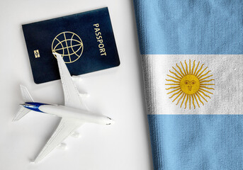 Flag of Argentina with passport and toy airplane. Flight travel concept.
