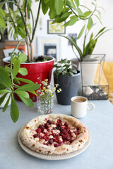 Dessert pizza with raspberries in a plate on the table