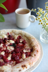 Dessert pizza with raspberries in a plate on the table