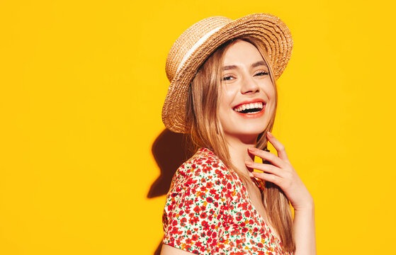 Portrait of young beautiful smiling blond female in trendy summer clothes. carefree woman posing near yellow wall in studio. Positive model having fun indoors. Cheerful and happy. In hat