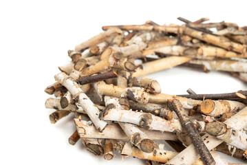 Real birch twig wreath. Birch tree branches arranged in a large circular nest shape. Natural wood decoration used for table center pieces or seasonal door hanger. Selective focus. Isolated on white.