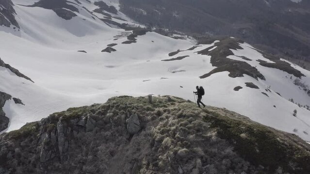 Adventurous hiker going trekking in remote mountains reaching mountain top