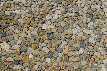 
A wall made of stones of different colors and shapes