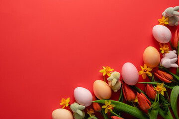 Easter holiday concept. Easter picture, multi-colored eggs, spring flowers on a red background. Happy Easter