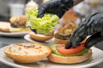 Chef cooking burger, close-up, making sandwich, fast food concept, recipe of preparing homemade...