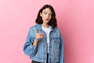Teenager Ukrainian girl isolated on pink background intending to realizes the solution while lifting a finger up