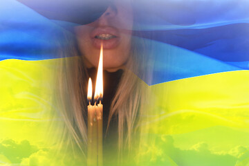 Girl praying on the background of the national flag of Ukraine. War in Ukraine. Stop war. Patriotism