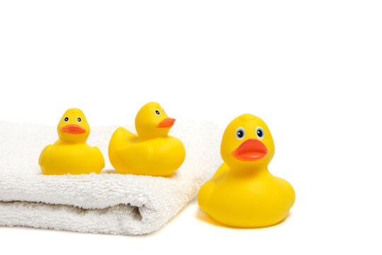 Yellow rubber ducklings on a white terry towel.