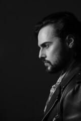 Black and white profile photo of bearded stylish handsome confident man. Indoor.
