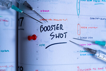 Booster shot Covid vaccination campaign and jab concept on agenda. Syringe on calendar with as a...