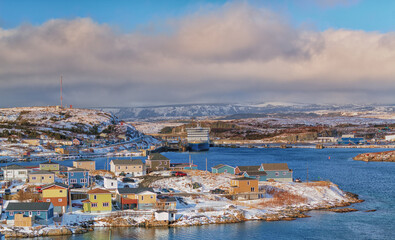 Fototapeta na wymiar A panoramic view of Channel Port aux Basques, Newfoundland during winter. The small coastline community has snow covered colorful houses, Marine Atlantic ferry and terminal with a sheltered harbour. 