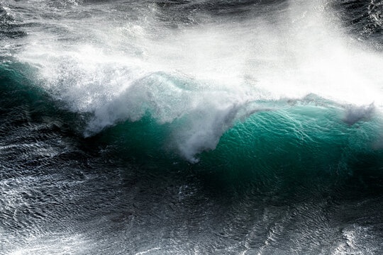 Breaking wave in rough sea thowing spray into the air