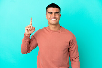 Fototapeta premium Young handsome man over isolated blue background pointing up a great idea
