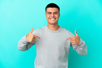 Young handsome man over isolated blue background proud and self-satisfied