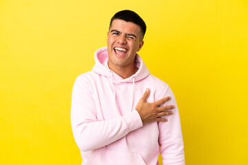 Young handsome man over isolated yellow background laughing