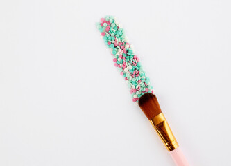 Makeup brush and multicolored round confetti with copyspace