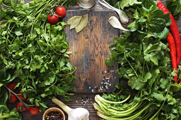Cooking background with cutting board, various of vegetables,  herbs and spices. Selective focus. Copy space
