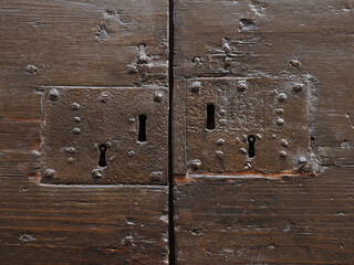 Old wooden door with four keyholes.