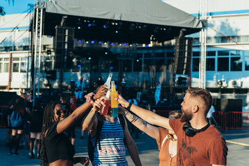 Group of friends drinking cocktails and having fun at music festival
