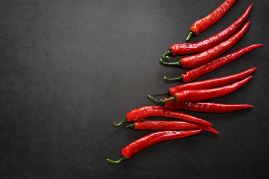 Red hot chili pepper with herbs and spices on dark background. Flat layot. Selective vocus