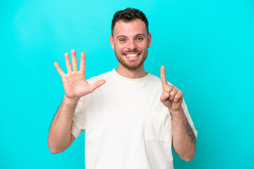 Young Brazilian man isolated on blue background counting six with fingers