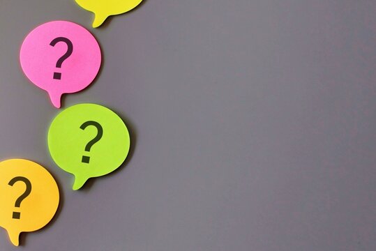 Top view image of speech bubble with question mark on gray background. Copy space for text.