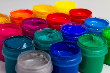 Selective focus open jars with gouache of different colors close-up. Hobby - painting