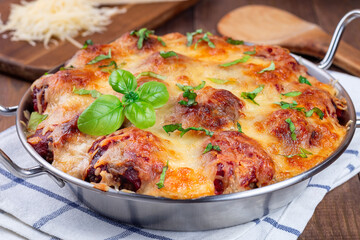 Mac and cheese with meatballs, mozzarella, tomato sauce and basil, in metal backing dish, horizontal