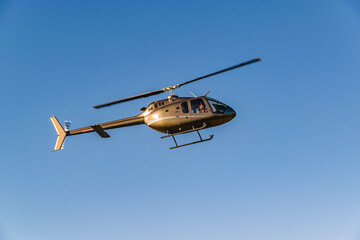 Fototapeta na wymiar Helicopter Flying Over Blue Sky