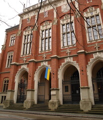 Obraz premium Main building of Jagiellonian University in Krakow, Poland, decorated with flag of Ukraine to show solidarity with country attacked by Russia
