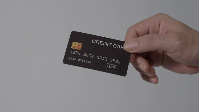 Using credit card for payment. Paying using a credit cards. Man hand giving Creditcard to woman hand. Isolated background. Cashless technology and credits card payment shopping concept. 4k footage.