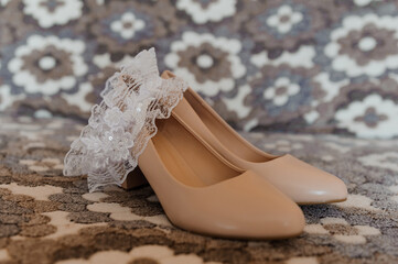 Bride's accessories. Women's shoes leather, garter, bridal bouquet, candles, pendant
