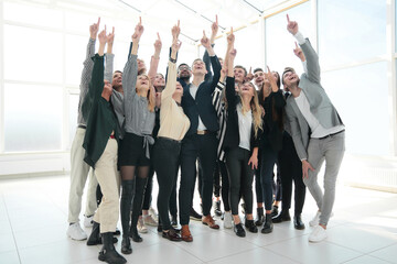 large group of happy business people pointing up
