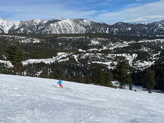 Scenic view of a skier on the slopes of Big Sky Ski resort in Montana on a sunny winter day