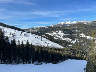Scenic view of the snow covered slopes and mountains at Big Sky Ski Resort in Montana on a sunny...