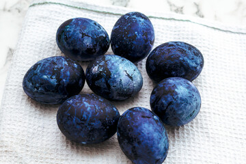 Cosmic colored eggs lie on a white waffle towel on a marble table. Easter eggs on the table