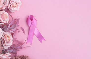 Pink ribbon and flowers on pink background with space for text. Women's day concept and breast cancer awareness 