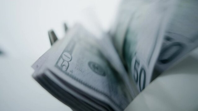 Money counting machine. Dollar banknotes on a bill counter. Modern bank equipment is processing usa currency. Automatic operations of cash. Banking or commercial activity and investment concept