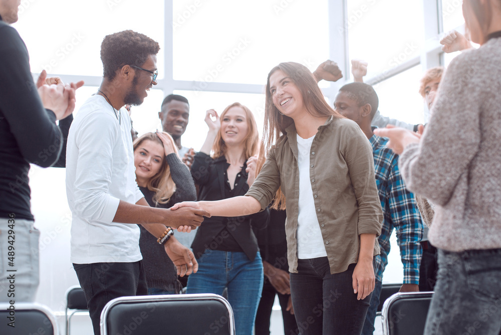 Wall mural group of happy young people congratulating their colleague