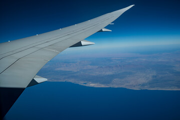 Fototapeta na wymiar Airplane wing seen from the window, in the background the west coast of the Arabian Peninsula, Red Sea