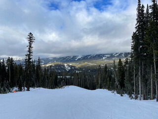 Scenic view of snow covered slopes at a ski resort in Montana on a cloudy winter day