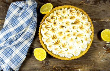 homemade lemon meringue pie with lemon fruit on wooden background