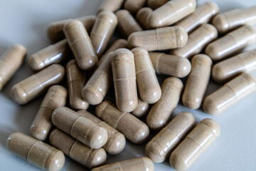 Brown capsules close-up. The scattering of capsules on a light background is close.