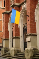 Foto auf Leinwand Entrance to main building of Jagiellonian University in Krakow with hanging flag of Ukraine to show solidarity with Ukrain attacked by Russia © Wioletta